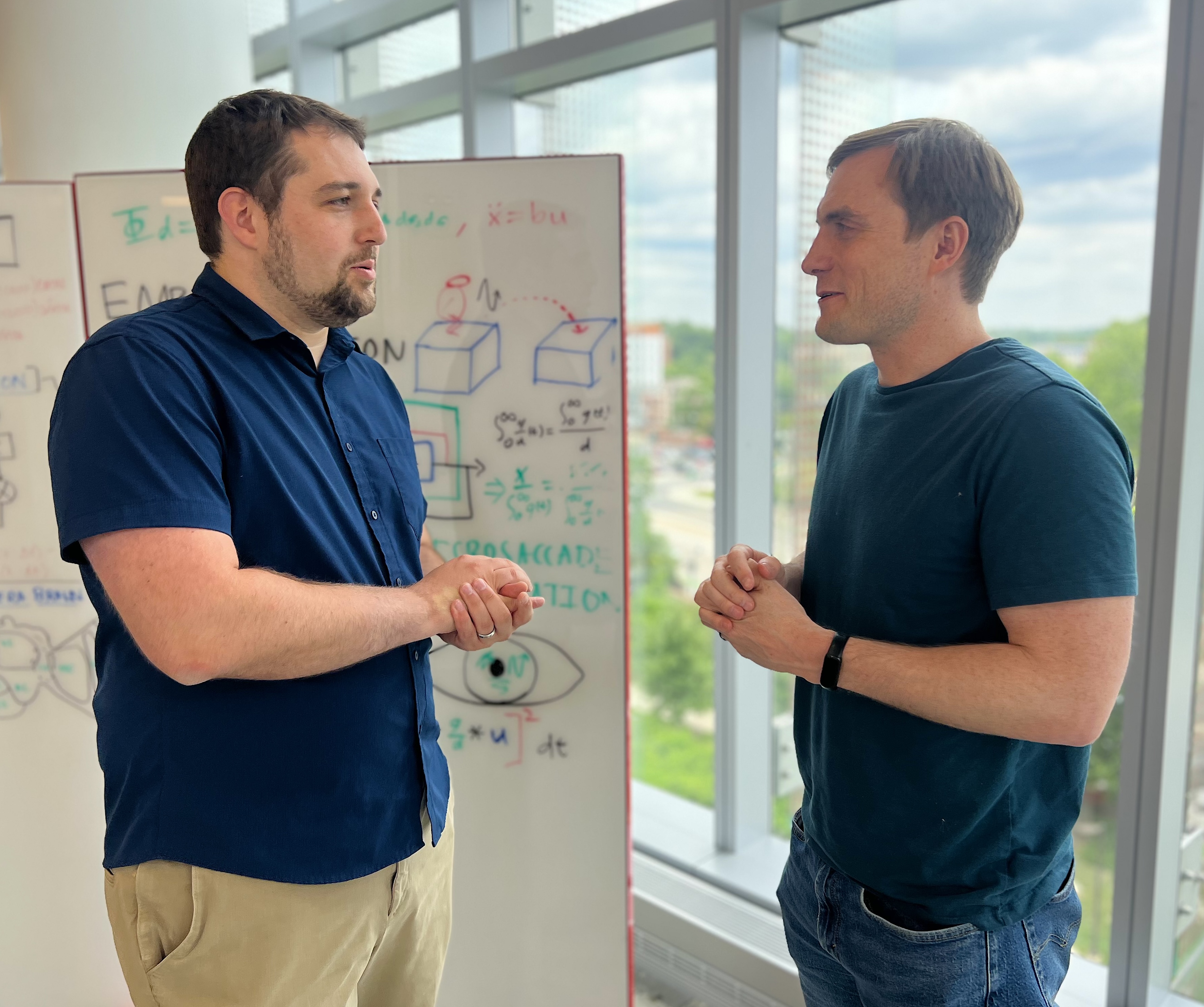 Levi Burner (left) and Christopher Metzler discuss research.