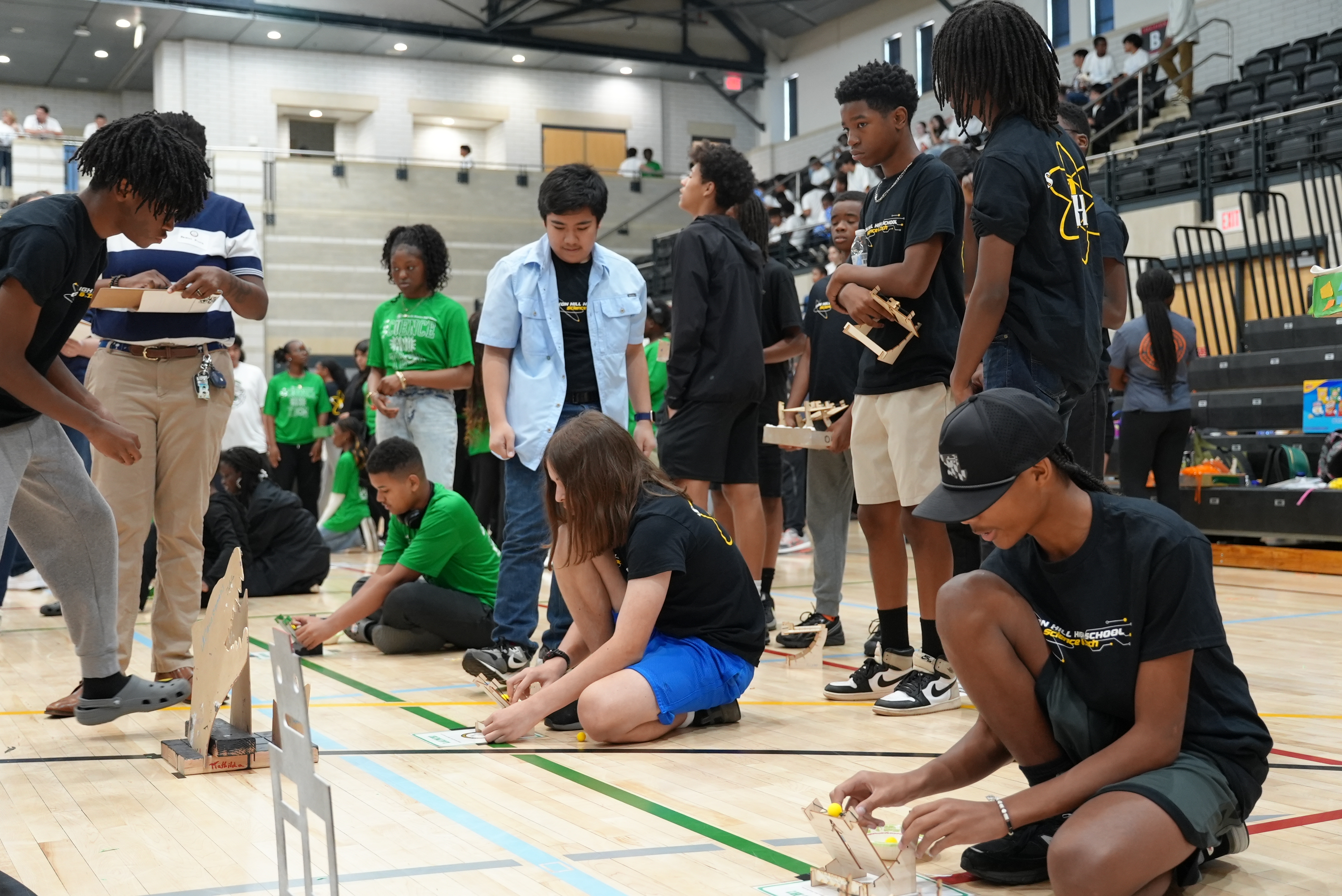 Students engage in a STEM activity, which involved launching small balls at targets.