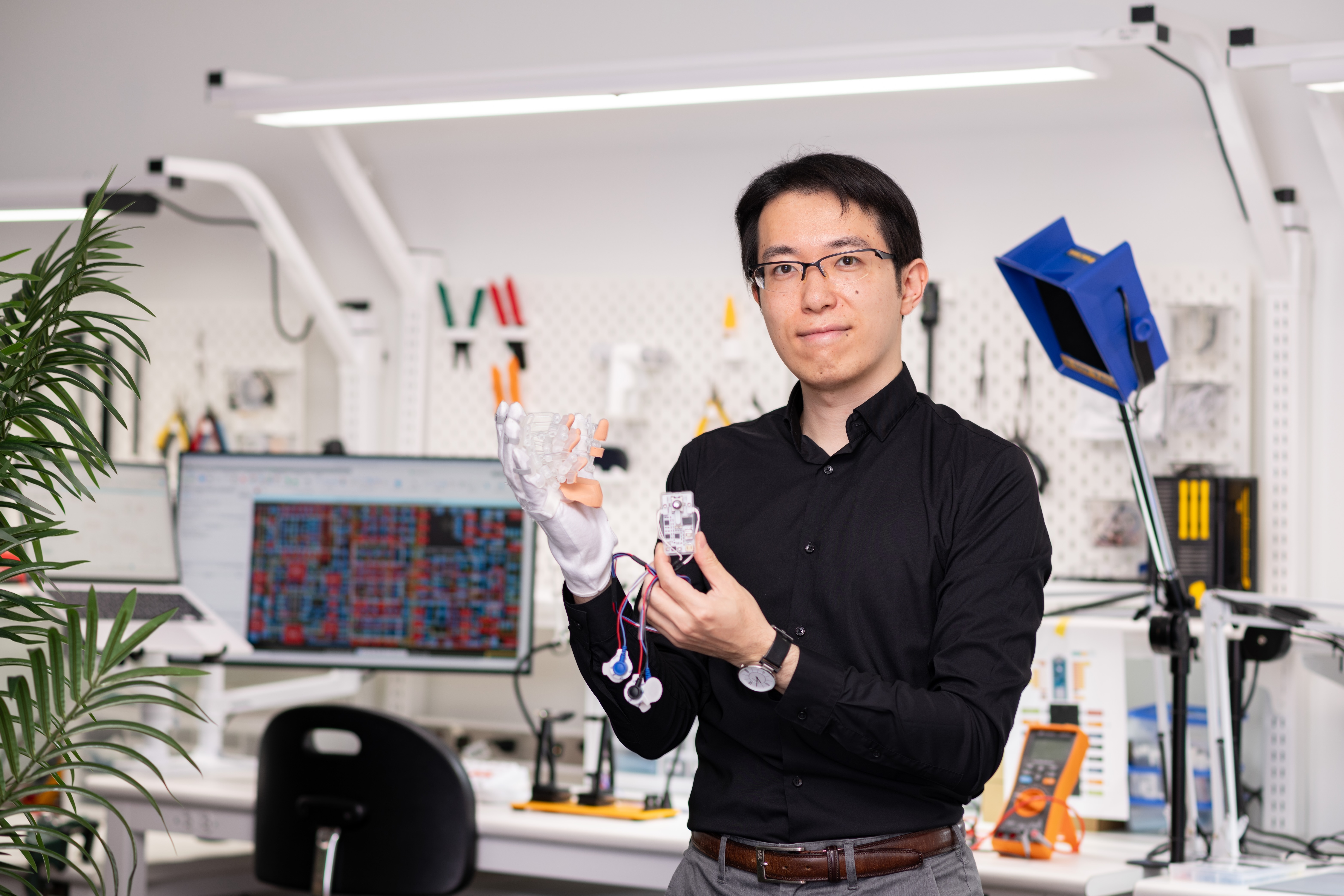 Nishida wearing all black and tech device on hand
