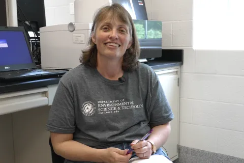 Stephanie smiling in lab wearing department T-shirt
