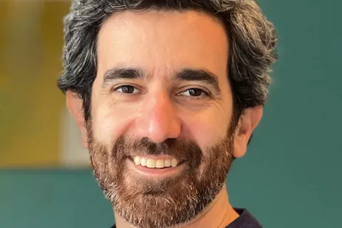A photo of Mohammad Hafezi standing in front of a green background. 