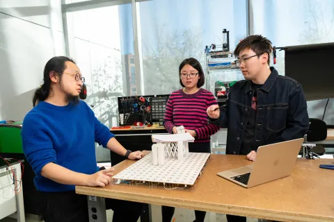 Working in his Small Artifacts (SMART) Lab, Assistant Professor of Computer Science Huaishu Peng and doctoral students Zining Zhang (center) and Jiasheng Li (right) discuss technology that can assist sight-impaired people.