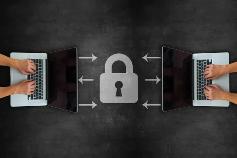 Two laptops with a lock between them.