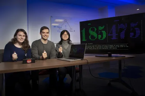 Computer science professor Jordan Boyd-Graber, with appointments in UMIACS and the Language Science Center, watches as former Ph.D. students Jo Shoemaker, Denis Peskov, and Michelle Yuan test an earlier version of his AI question-and-answer system, QANTA.