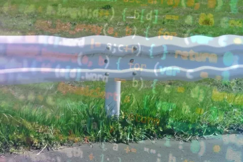 An image of a guardrail with computer code superimposed over it in blue and orange text. 