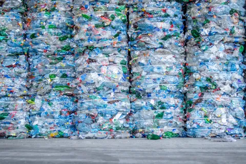 Thousands of plastic bottles and plastic waste packaged together to form a wall.