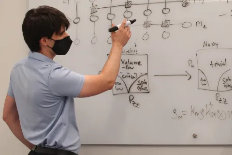 Michael Gullans draws a diagram on a white board.