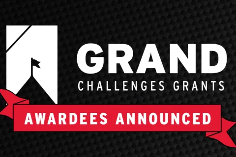 A graphic announcement featuring a white logo and the text "GRAND CHALLENGES GRANTS" next to a red ribbon that reads "AWARDEES ANNOUNCED" against a black textured background.