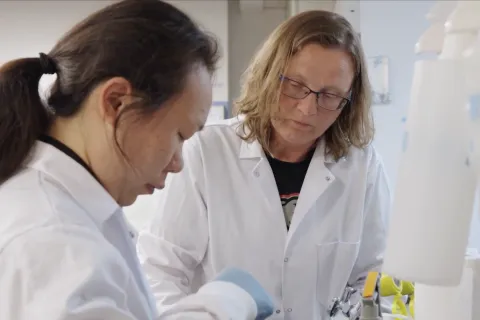 Birthe Kjellerup and graduate student in white lab coats