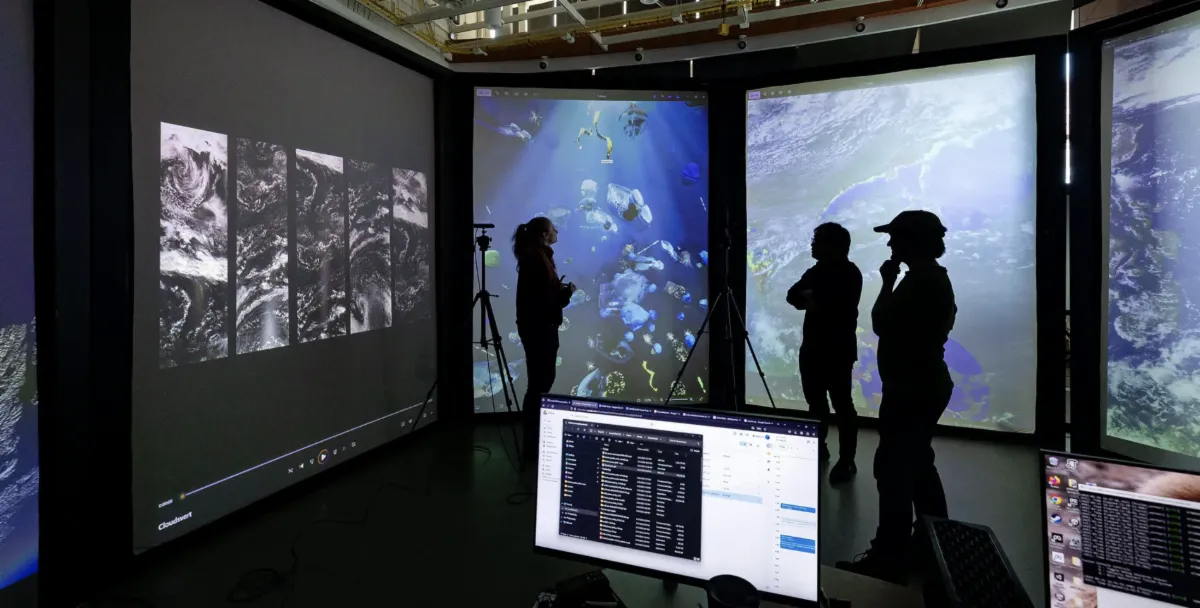 3 people standing in front of multiple projections