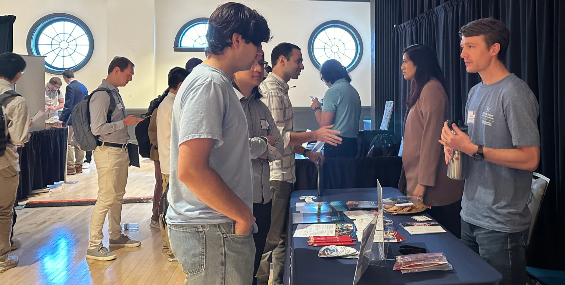 A group of students at a conference talking to each other
