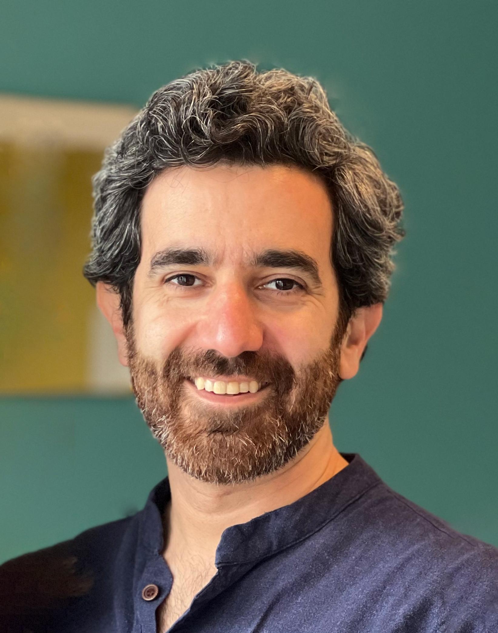 A photo of Mohammad Hafezi standing in front of a green background.