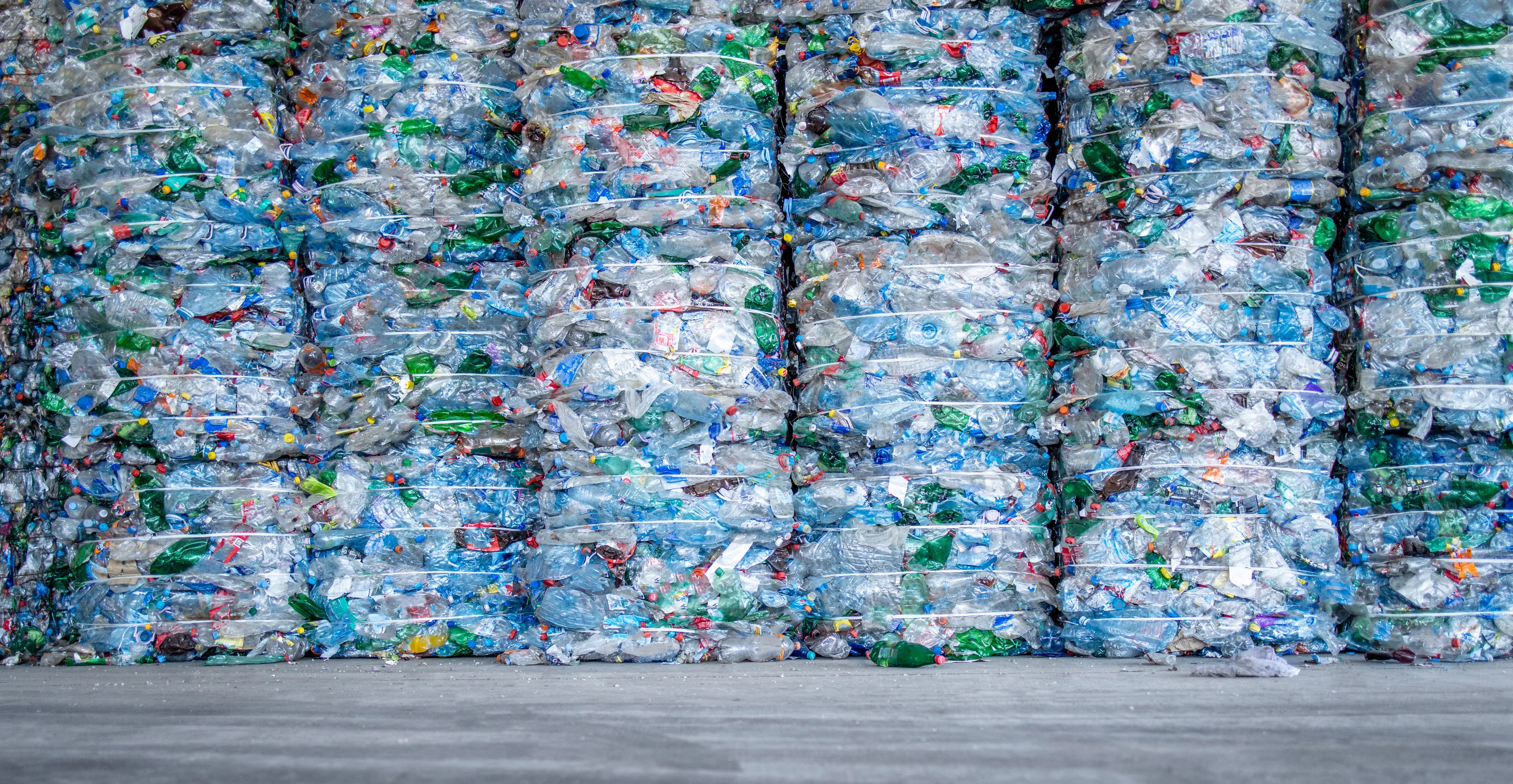Thousands of plastic bottles and plastic waste packaged together to form a wall.