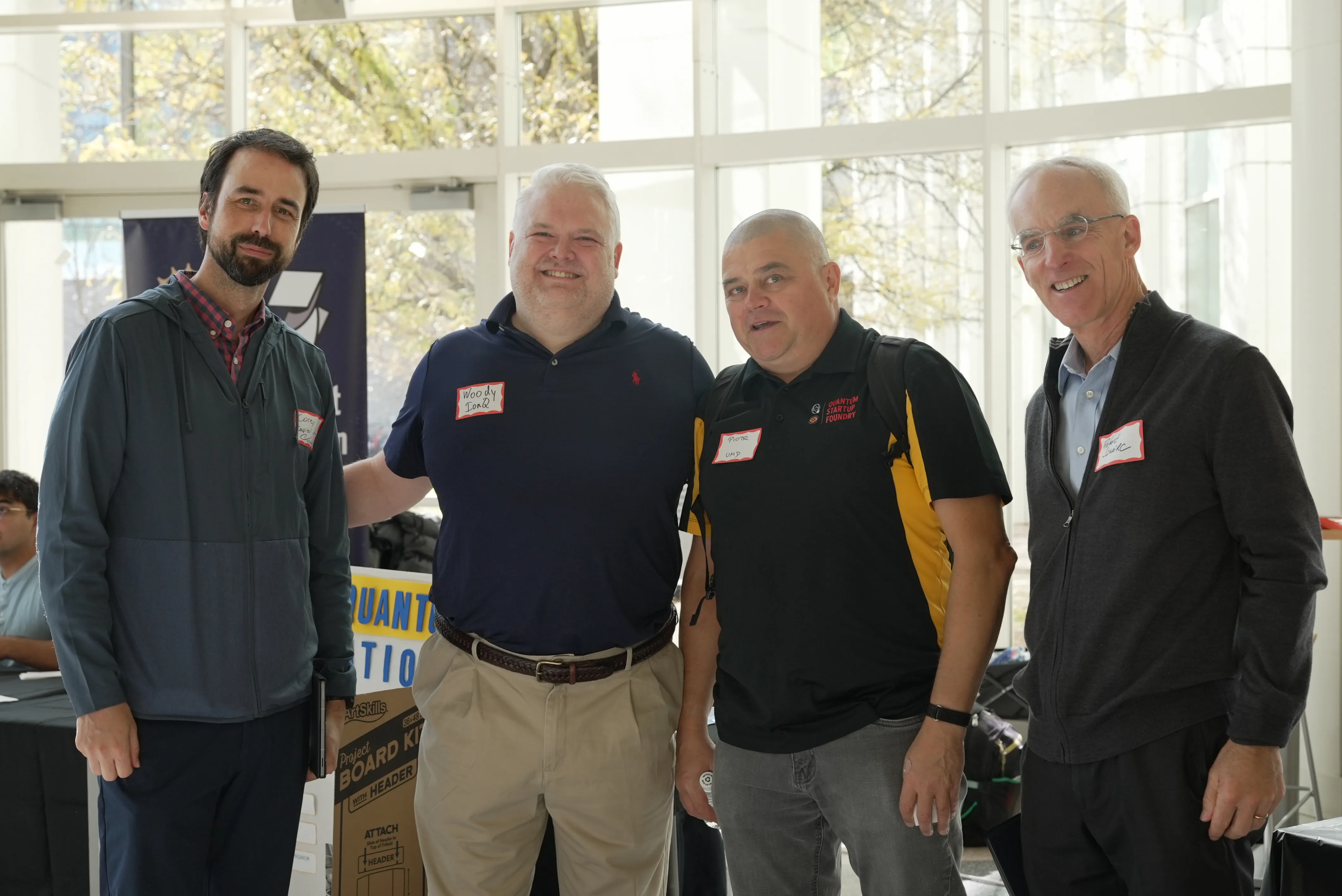 four men with name tags at career fair