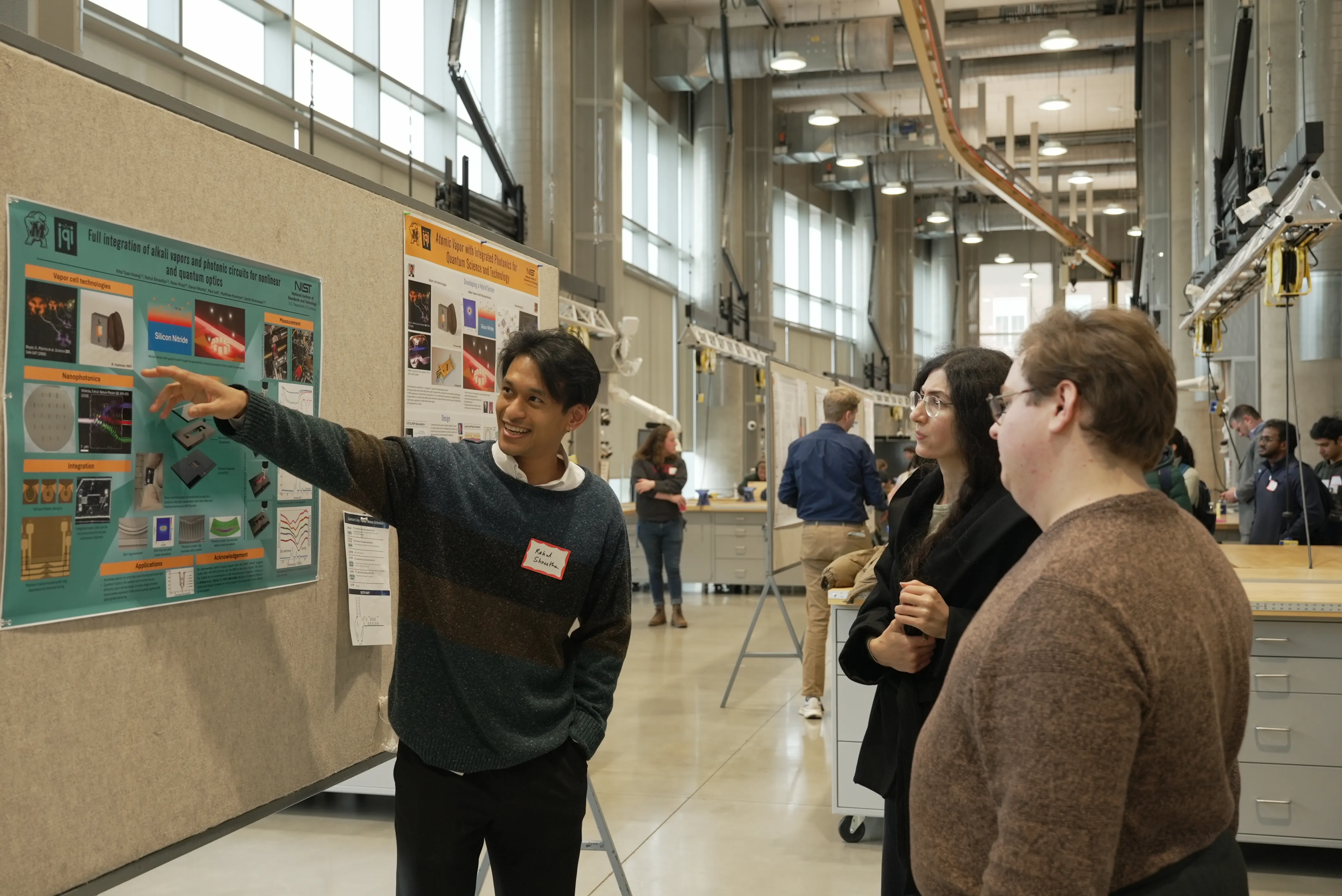 three students looking at research poster
