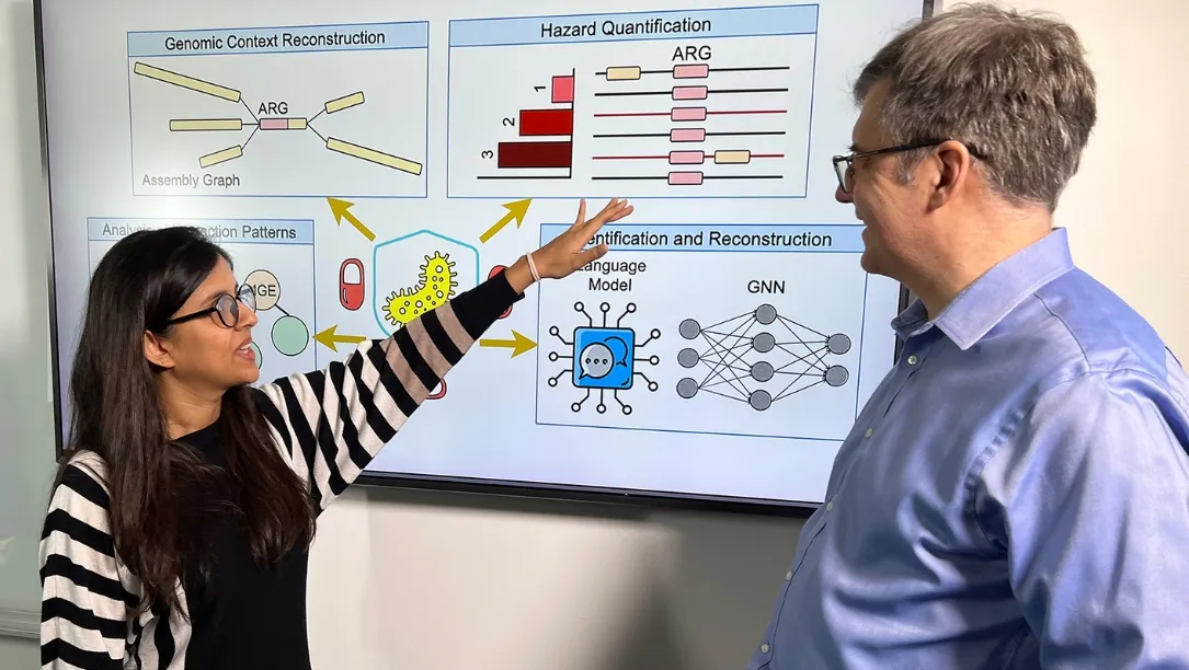 Nazifa Ahmed Moumi pointing at a presentation containing machine learning models and metagenomic diagrams with Mihai Pop