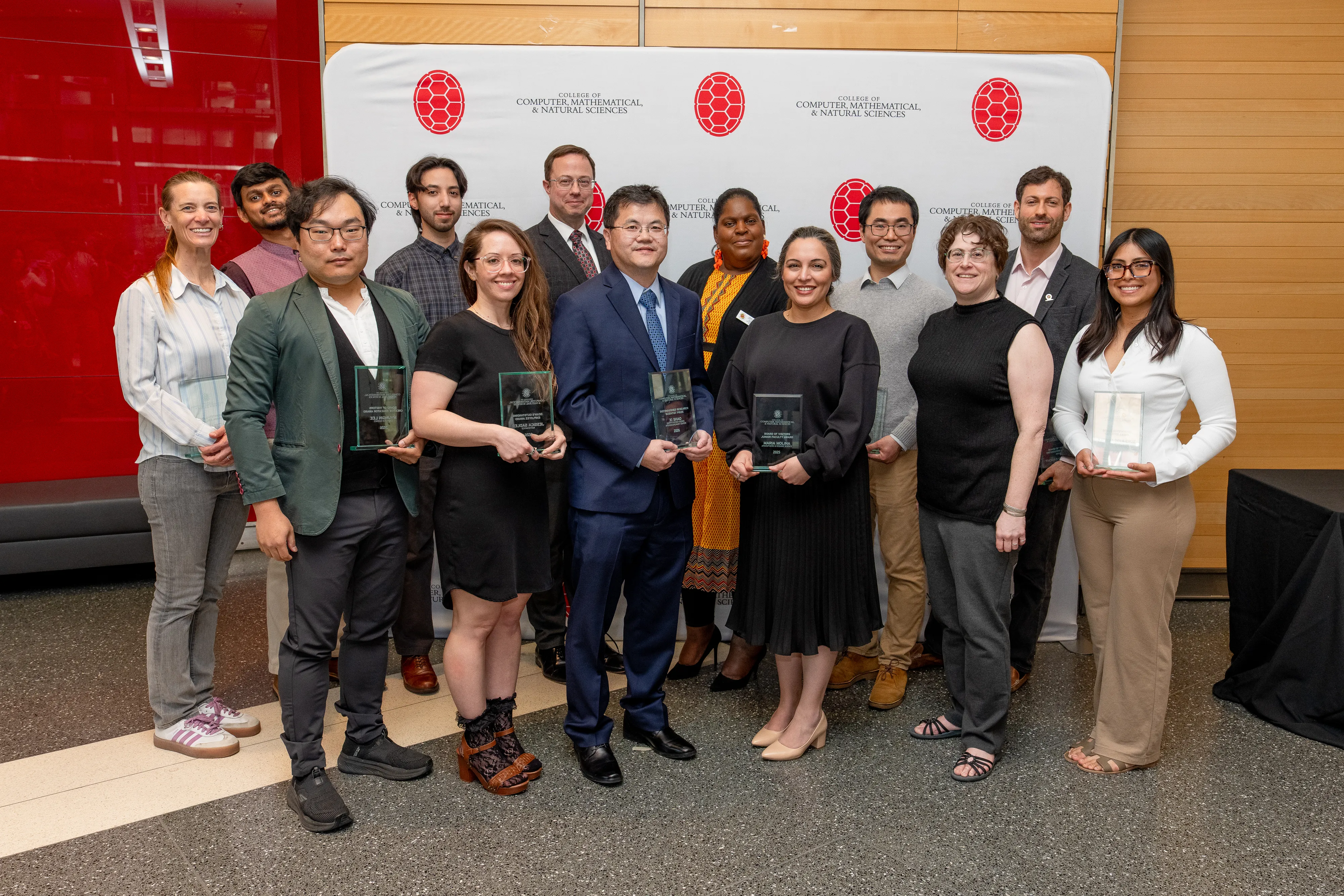 group of award winners holding glass awards