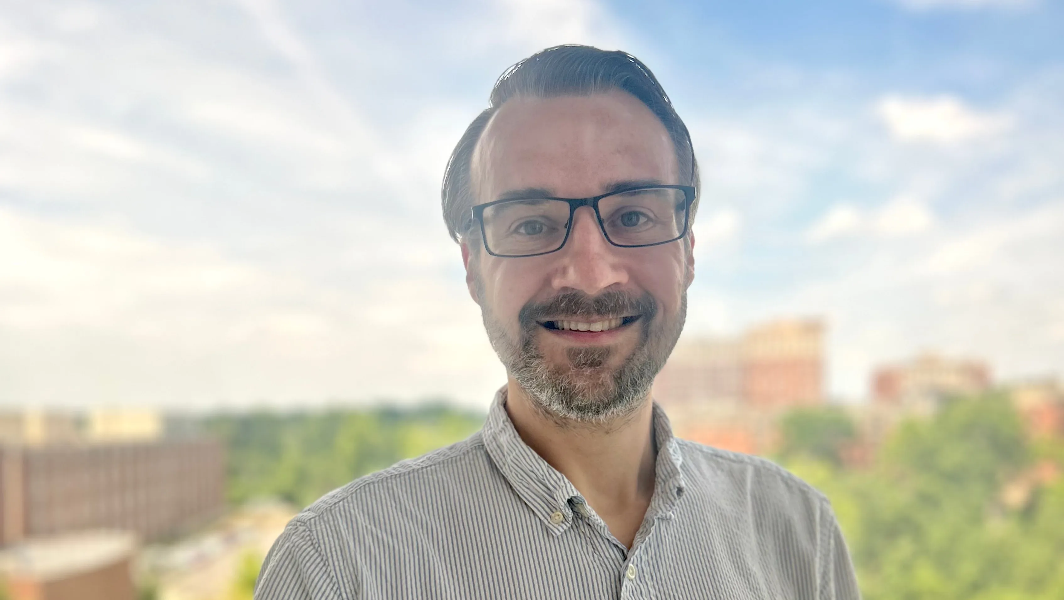 A headshot of Rob Patro with the UMD campus in the background. 
