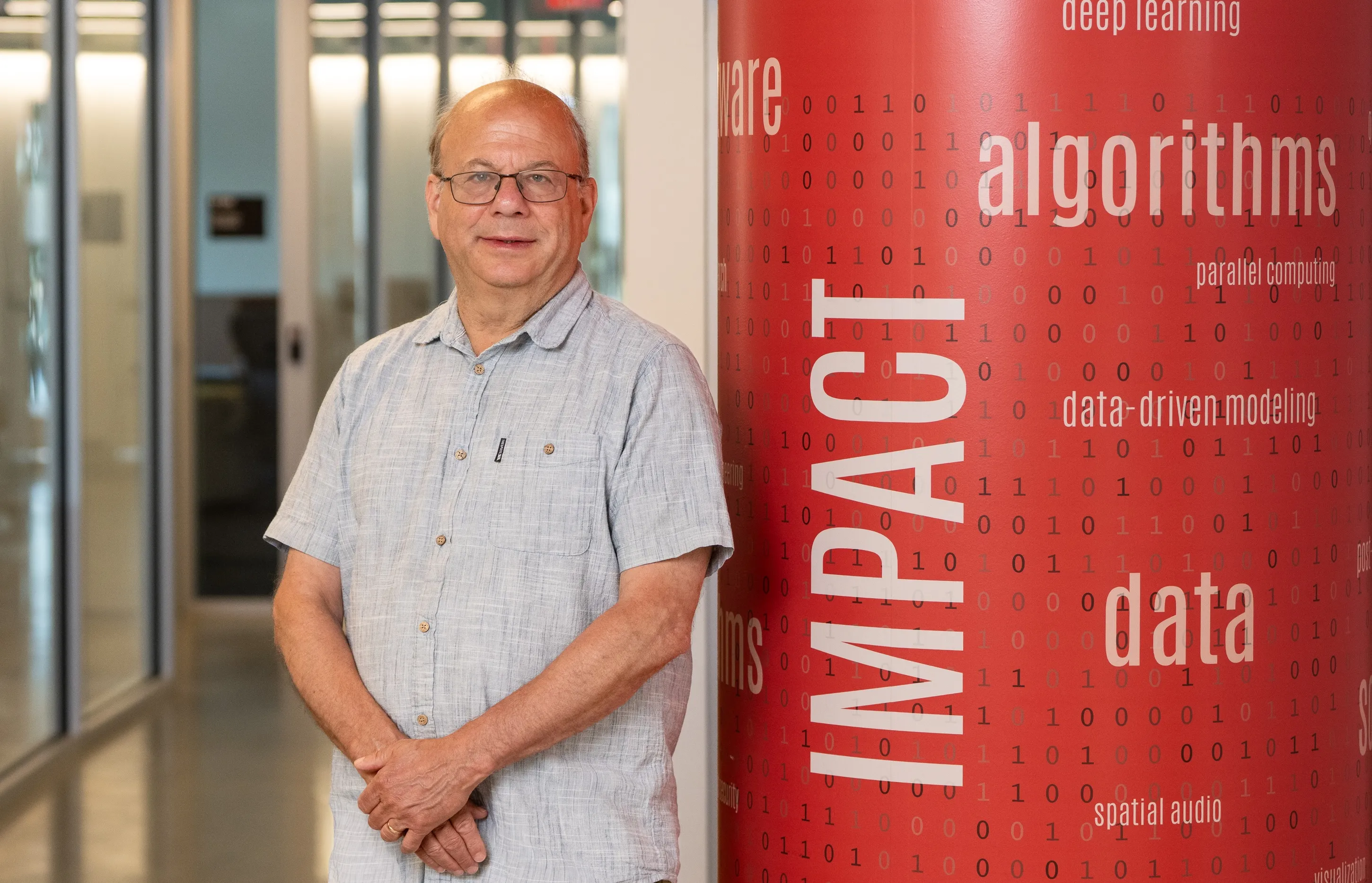 David Jacobs standing next to column that says Impact