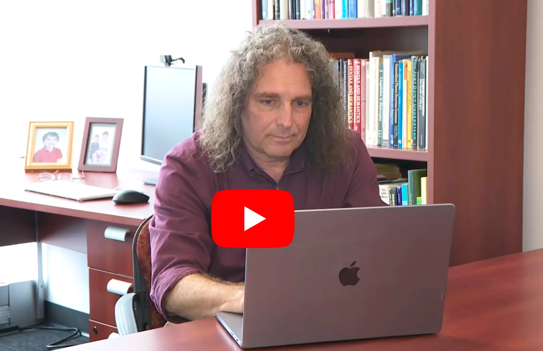 Philip Resnik sits at desk with laptop and YouTube icon