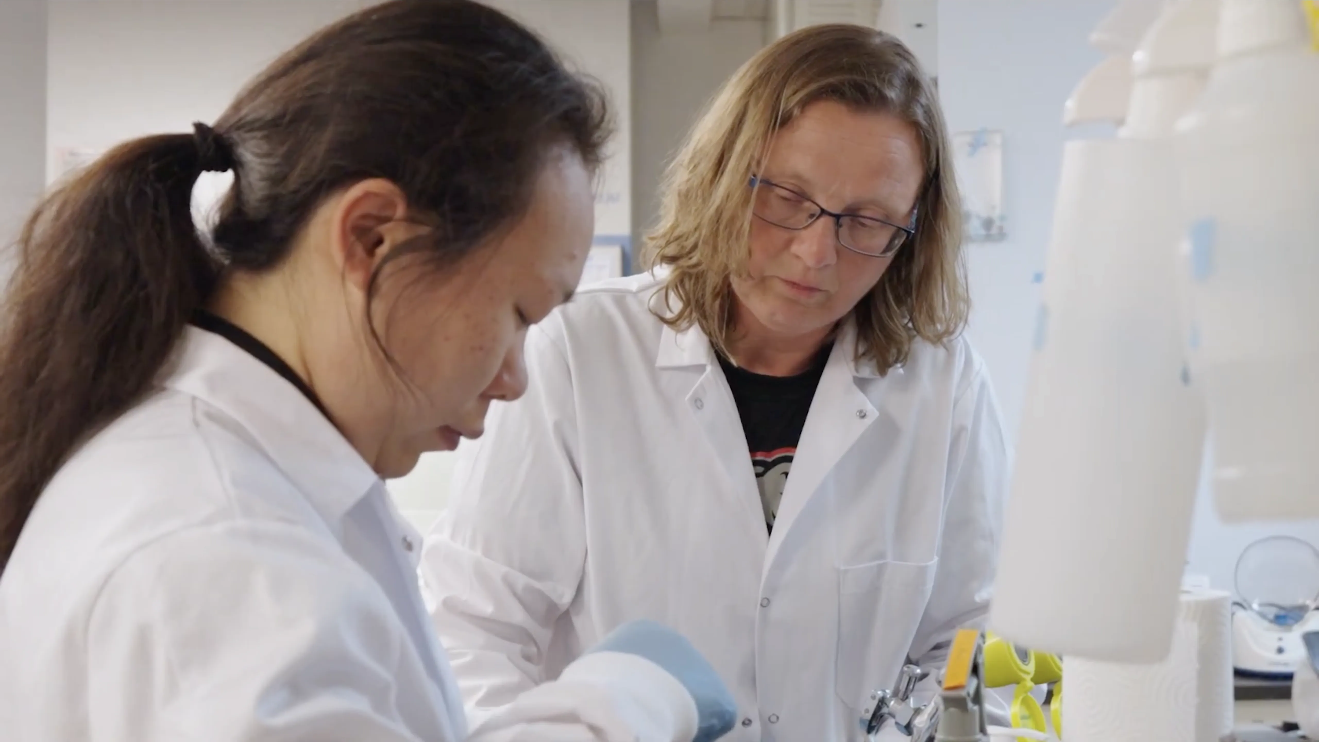 Birthe Kjellerup and graduate student in white lab coats